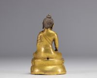 Sculpture of a seated Buddha on a gilded bronze base