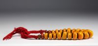 China - Amber necklace composed of twenty-three large pearls separated by felt lozenges.