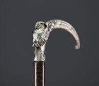 A silver-plated bronze cane with a handle carved with an owl with open wings.