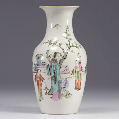 A Famille Rose porcelain vase decorated with figures and a tree on a white background