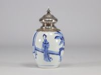 A white and blue vase decorated with women surmounted by a silver stopper with a mark under the piece from the Kangxi period (1661-1722)