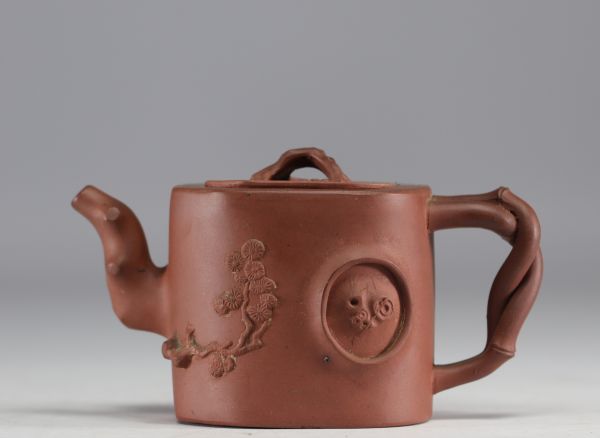 China - Yixing teapot in terracotta with floral decoration in relief, debossed mark on the underside.